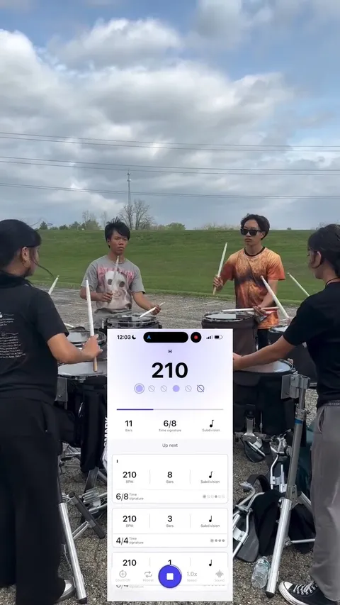 Arcadia HS Percussion's drumline rehearsing in the lot with Subdivide running at 210 BPM on a phone in the foreground